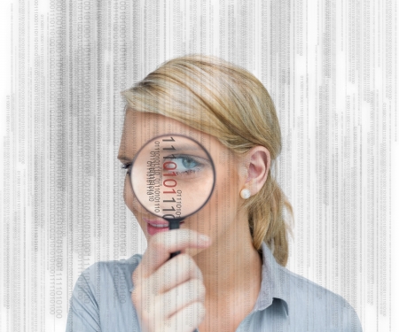 Woman standing while holding a magnifying glassの写真素材