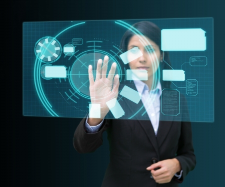 Businesswoman standing while touching at a hologram concentratedの写真素材