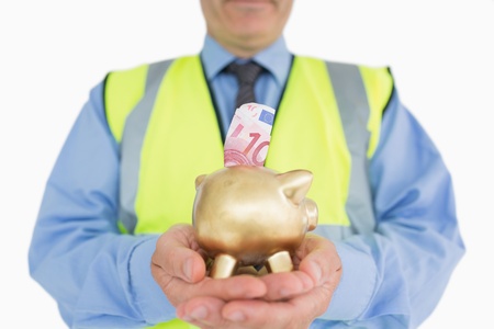 Man in vest holding a piggy-bank with money in itの写真素材