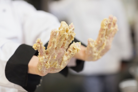 Chef's hands covered in dough