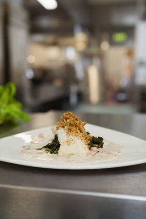 Plate of resteraunt food ready to go on the counter of kitchen
