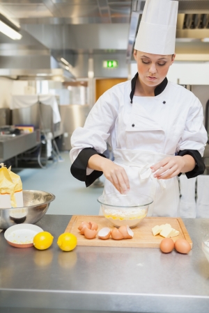 Female baker making dough in the kitchenの写真素材