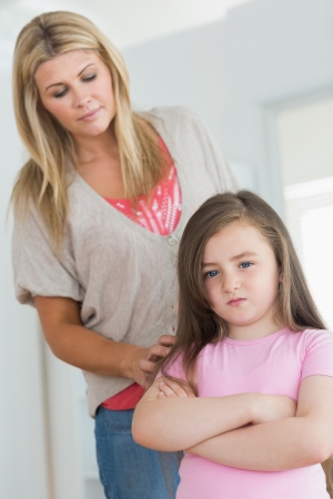Mother trying comfort angry daughter in kitchenの写真素材