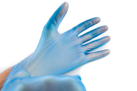 Man putting on blue disposable rubber gloves 