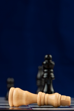 White queen lying at the chessboard blue backgroundの写真素材