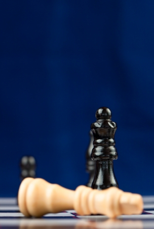 White king is down in chess game against blue bakcgroundの写真素材