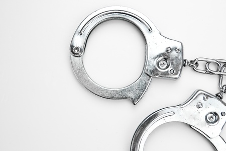 Silver manacles lying against white backgroundの写真素材