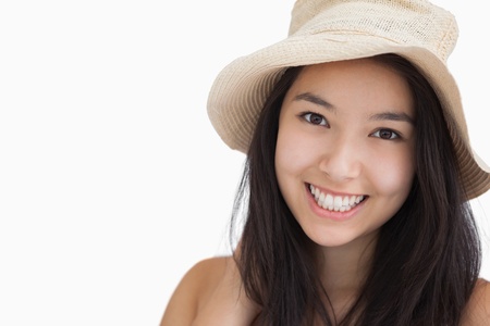 Smiling woman with a straw hat on white backgroundの写真素材