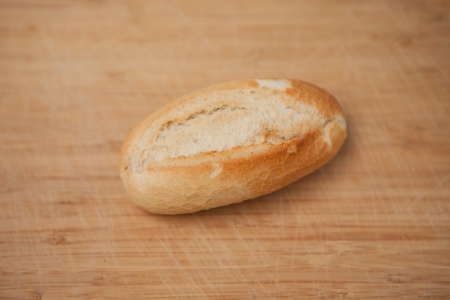 Small baguette laying on wooden table