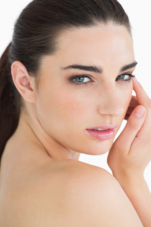 Glamorous woman touching her face while looking at cameraの写真素材