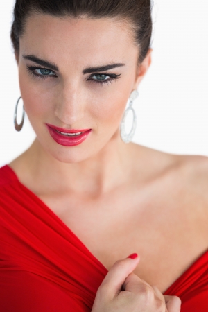 Glamorous woman touching her red dress while looking at cameraの写真素材