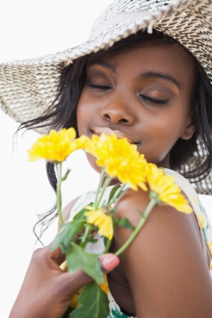 Woman smelling yellow flowers with eyes closed の写真素材