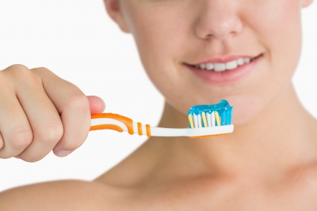Woman holding the toothbrush in the white backgroundの写真素材