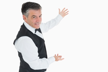 Well-dressed man showing us something with open armsの写真素材