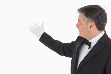 Enthusiastic waiter showing us something on the background の写真素材