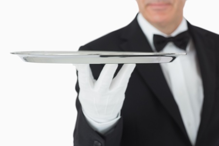Smiling waiter balancing silver trayの写真素材