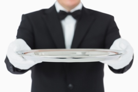 Waiter holding a silver tray with both hands on white backgroundの写真素材