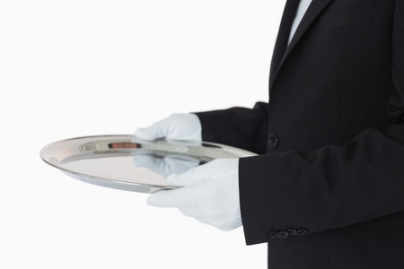 Man in suit holding silver tray on white backgroundの写真素材
