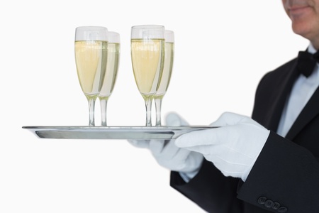 Waiter carrying silver tray full glasses of champagne の写真素材