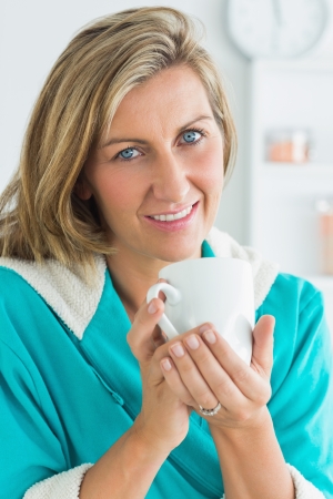 Smiling woman in dressing gown looking directly into the cameraの写真素材