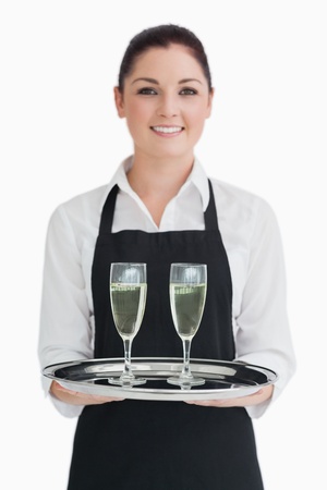 Waitress holding champagne glasses on a silver trayの写真素材