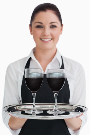 Waitress holding two glasses of wine on a silver tray の写真素材