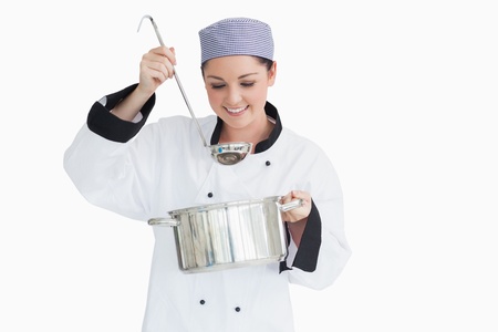 Happy cook with a ladle and a pot on white background