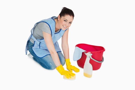 Smiling cleaning woman washing the floor on white background