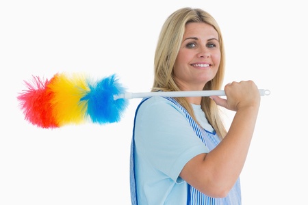 Smiling cleaning woman holding feather duster in the white background