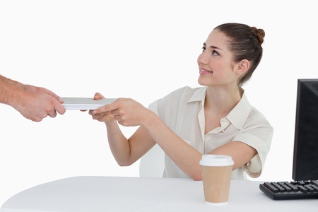 Businesswoman receiving documents against a white backgroundの写真素材
