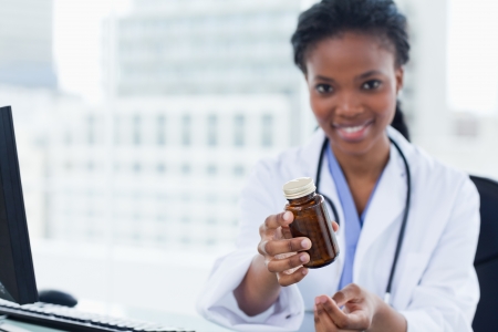 Female doctor giving medication in her officeの写真素材