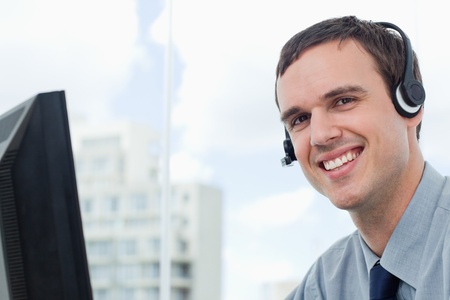 Happy office worker using a headset his office