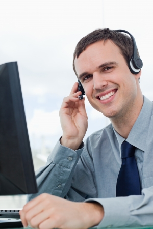 Portrait of an office worker using a headset in his officeの写真素材
