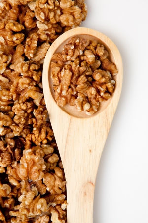 Wooden spoon with nuts against a white backgroundの写真素材