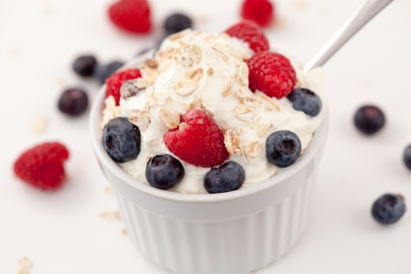 Sweet berries in whipped cream against white backgroundの写真素材