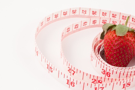 Close up of a strawberry surrounded by a ruler against a white backgroundの写真素材