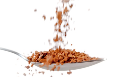 Chocolate powder falling in a spoon against white backgroundの写真素材
