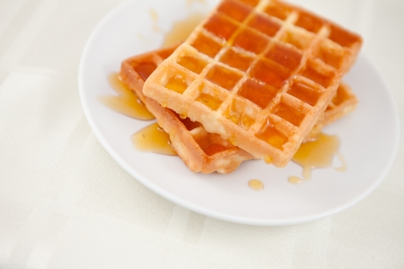 Waffles spread with honey on a tableの写真素材
