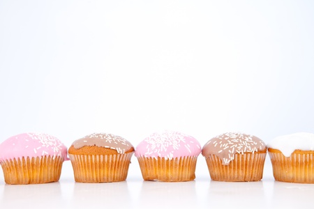 Muffins lined up against a white backgroundの写真素材