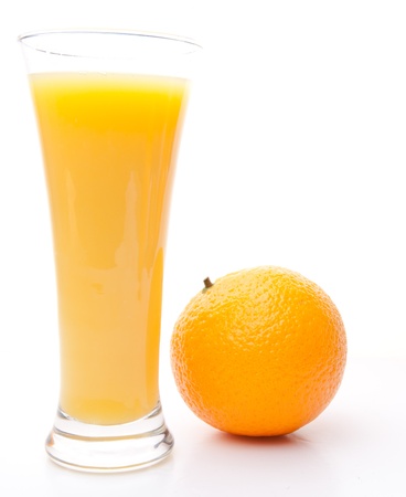 Orange next to a glass of orange juice against white backgroundの写真素材