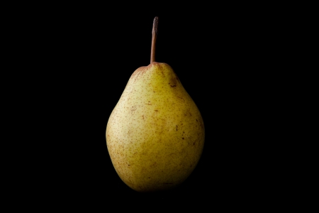Green pear against a black baclgroundの写真素材