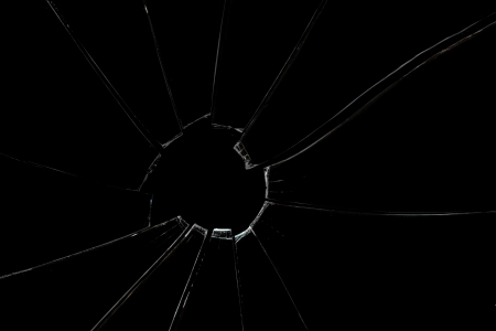 Broken and crackled glass against a black backgroundの写真素材