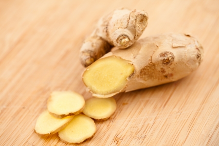 Slice of ginger and piece of ginger on a worktopの写真素材