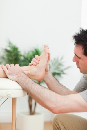 Close up of a physiotherapist massaging a foot in a roomの写真素材