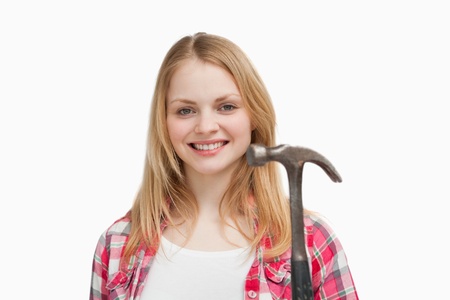 Woman holding a hammer against white backgroundの写真素材