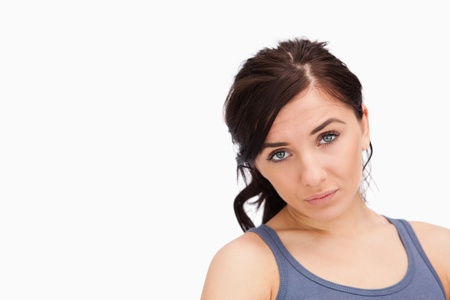 Unhappy young woman looking at camera against white backgroundの写真素材