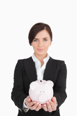 Businesswoman holding a piggy-bank against white backgroundの写真素材