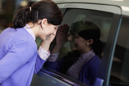 Smiling woman looking inside a carの写真素材
