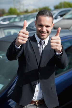 Happy man raising his thumbs outdoorsの写真素材