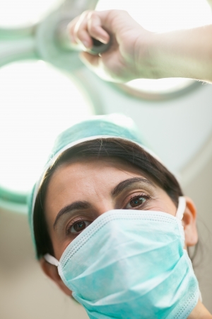 Woman surgeon holding a surgical lighting in a surgical roomの写真素材